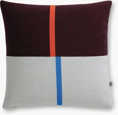 a brown and blue pillow with an orange stripe on the side, sitting on a white surface