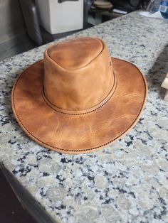 Handmade Australian outback style cowboy hat. Each hat is made with all natural veg-tanned leather. The hat size is 22 inches around. All hats can be custom fitted to your exact head measurements. Just send me a message if you need to have it custom fitted. Also If you do not like any of the colors you see here, send me a message and I can show you other leather colors that I have available. Wide Brim Distressed Brown Hat For Western-themed Events, Distressed Brown Wide Brim Hat For Western-themed Events, Distressed Brown Wide Brim Hat For Western Events, Rugged Leather Wide Brim Fedora, Rugged Leather Wide-brim Fedora, Rugged Brimmed Fedora For Western-themed Events, Rugged Brimmed Hat For Ranch, Rustic Leather Hat For Western-themed Events, Rustic Leather Fedora For Rodeo