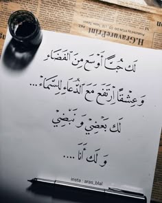 a piece of paper with arabic writing on it and a pen resting on top of it