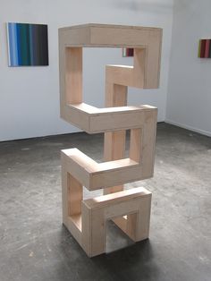 a wooden sculpture sitting on top of a cement floor