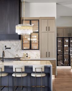 a kitchen with marble counter tops and bar stools