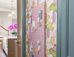 an open door leading to a kitchen with pink flowers on the wall and green trim