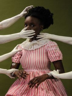 a woman with hands on her face standing in front of four white dogs'arms