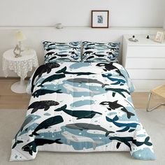 a bed room with a neatly made bed covered in blue and white comforter sets