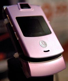 a pink cell phone sitting on top of a table