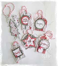 some christmas tags are hanging on a table