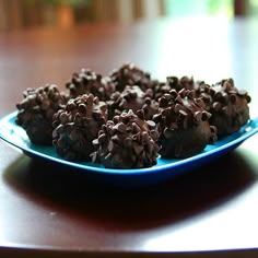 a plate full of chocolate covered donuts on a table