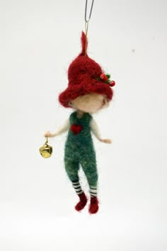 a little red haired girl ornament hanging from a string on a white background