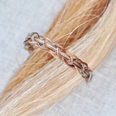 a close up view of some hair with an intricate braid on it's end