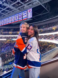 two people hugging each other at a hockey game