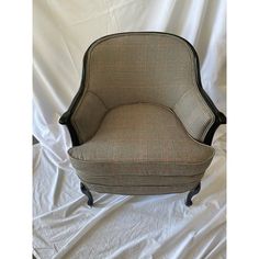 an upholstered chair on a white sheeted background with the fabric draped over it