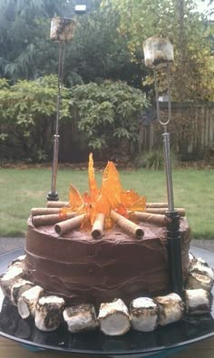 a chocolate cake sitting on top of a plate covered in frosting and wood logs