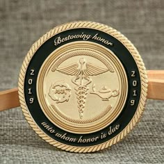 a gold and black medical medal on a brown belt