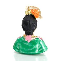 a green purse with an orange and pink flower on it's head, sitting in front of a white background