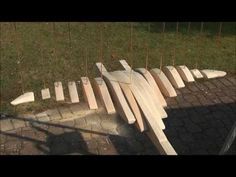 several pieces of wood sitting on top of a brick floor next to a fence and grass