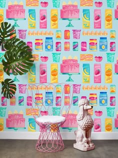 two chairs and a table in front of a colorful wallpaper with cakes on it