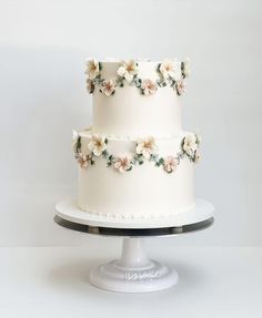 a three layer white cake with flowers on it