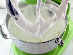 a green mixer with white cream in it