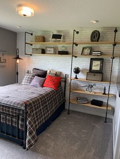 a bed room with a neatly made bed and some shelves on the wall above it