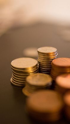 a pile of coins sitting on top of a table next to another stack of gold coins