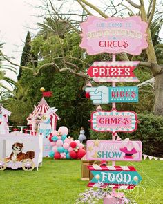 there are many signs on the grass in front of some trees and other decorations,