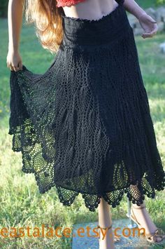 a woman is wearing a black crochet skirt and red top with her hands on her hips