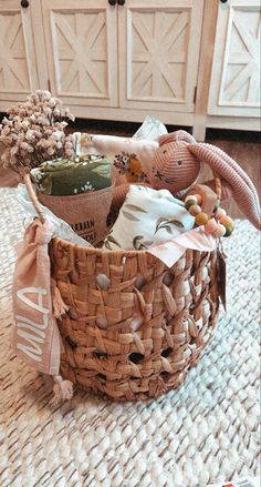 a basket filled with stuffed animals sitting on top of a rug