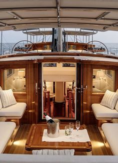 the inside of a boat with couches, tables and chairs on it's deck