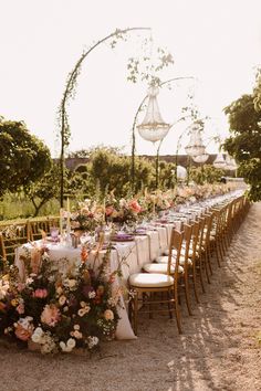 a long table set up with flowers and chairs