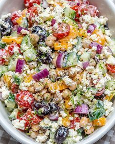 a salad with tomatoes, cucumbers, chickpeas and feta cheese