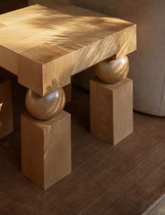 a wooden table sitting on top of a hard wood floor next to a chair and ottoman