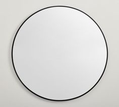 a round mirror on the wall with black trim around it and an empty space for text