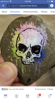 someone is holding a rock with a skull painted on it