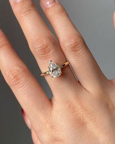 a woman's hand with a diamond ring on top of her finger, and the other hand holding an engagement ring