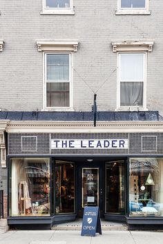 an open store front with the words the leader on it's sign in front