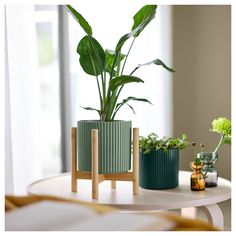 two green planters sitting on top of a white table