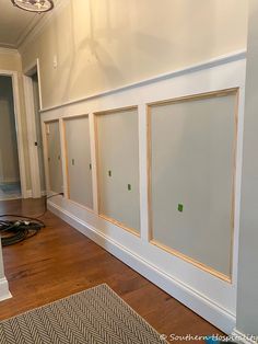 an empty room with white walls and wood trimmings on the wall, in front of a doorway