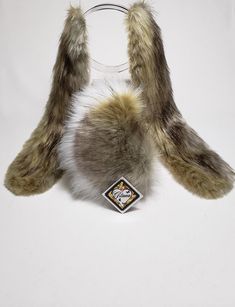 an animal fur headband and ear muffs are on top of a white surface