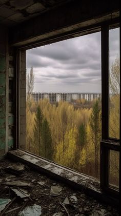 an empty room with a window looking out at the trees and buildings in the distance