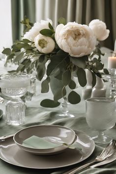 Elegant table setting with white peonies and green foliage centerpiece.