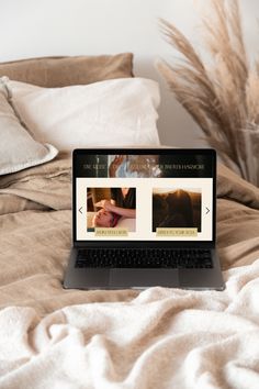 an open laptop computer sitting on top of a bed next to pillows and pillow cases