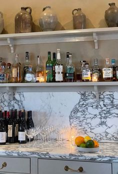 bottles and glasses are lined up on the counter top next to an assortment of liquors