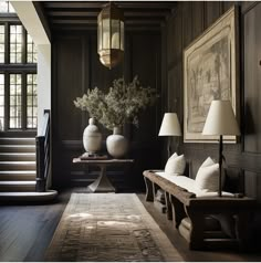 a living room with dark wood paneling and white vases filled with flowers on the table