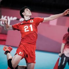 a man jumping up in the air to hit a volleyball