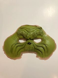 a green mask with an animal's face painted on it