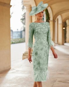 a woman in a green dress and hat