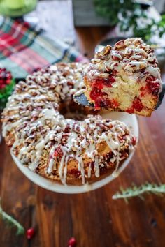 a bundt cake with white icing and cranberry toppings on a plate