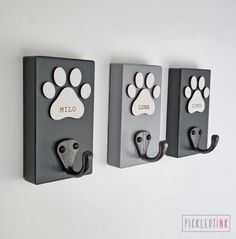 three wall hooks with paw prints on them and the words hello kitty written in white