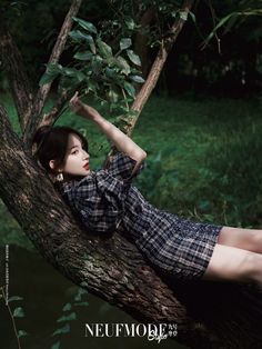 a woman laying on top of a tree branch