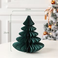 a green christmas tree sitting on top of a white table